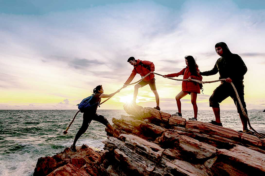 group helping person over edge