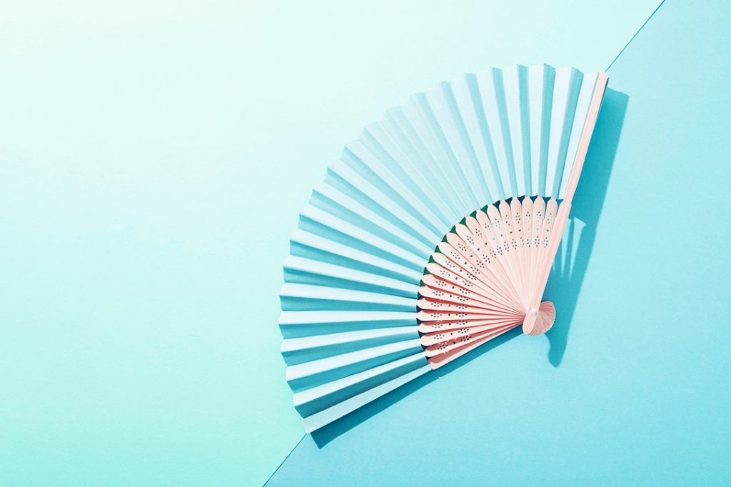 hand fan on colour background
