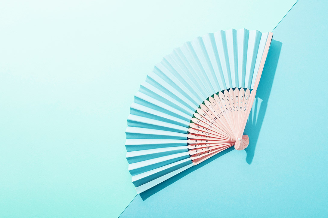 hand fan on colour background
