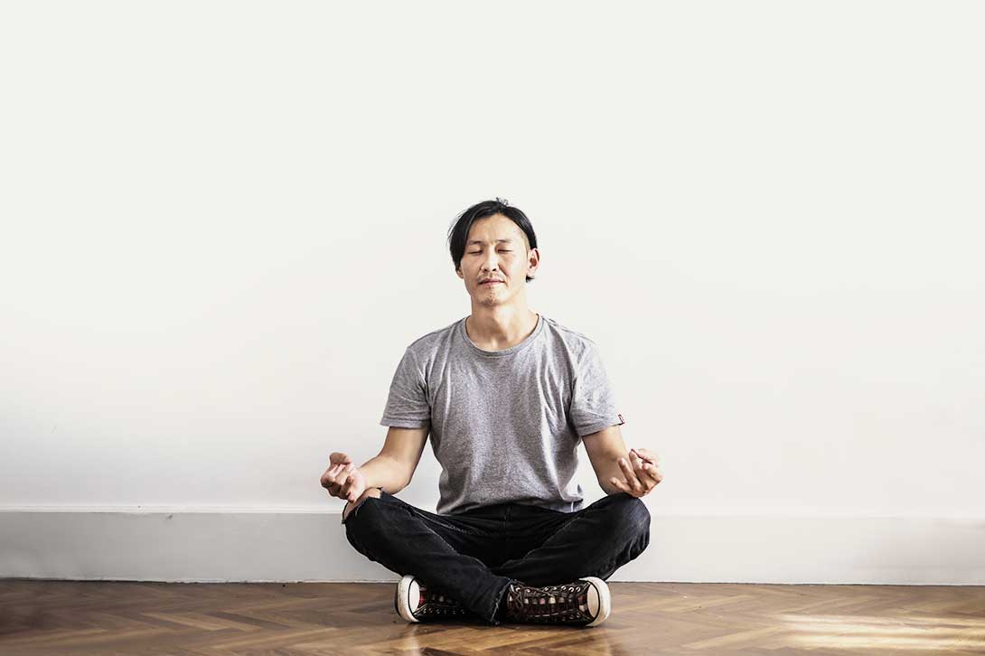 male in jeans sitting cross legged