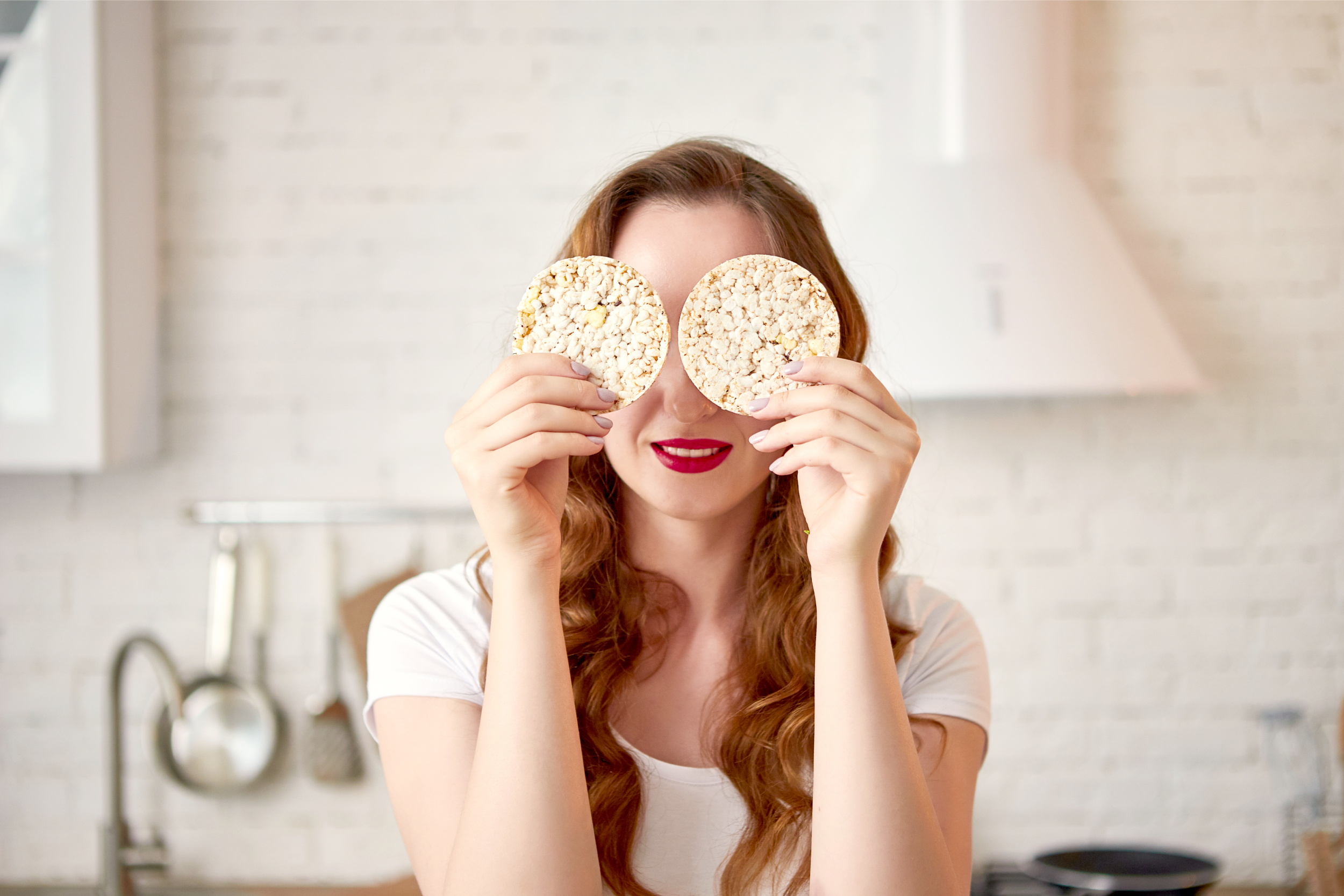 woman holding rice cakes in front of eyes