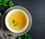 a bowl of chicken broth on a table