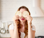 woman holding rice cakes in front of eyes